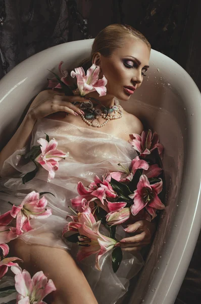 Frau im Bad mit Blumen — Stockfoto