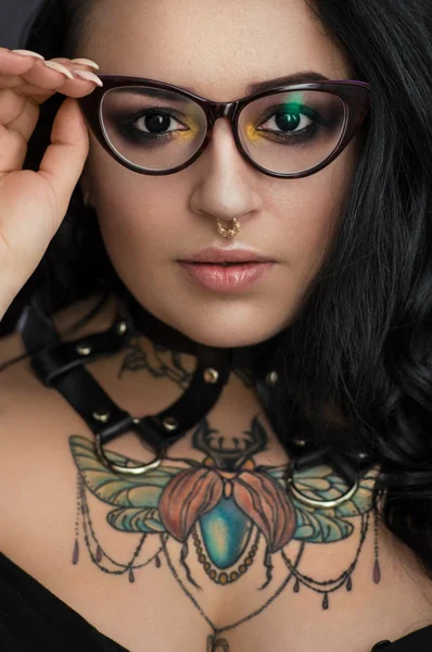 Woman in glasses with  tattoo on chest — Stock Photo, Image