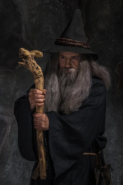 Old sorcerer with a wooden staff — Stock Photo, Image