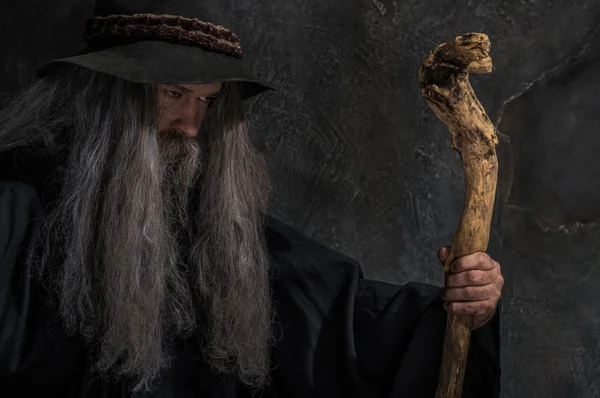 Old sorcerer with a wooden staff — Stock Photo, Image