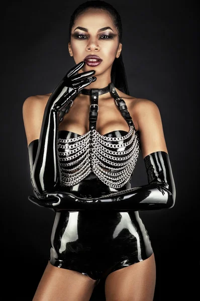 Femme en tenue de latex avec des chaînes métalliques — Photo