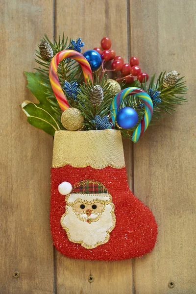 Christmas stocking with fir branches, berries and candy canes — Stock Photo, Image