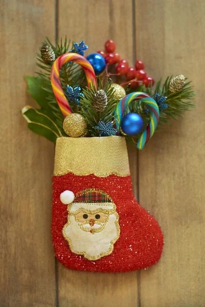 Різдвяний панчіх з ялинковими гілками, ягодами і цукерками Стокова Картинка