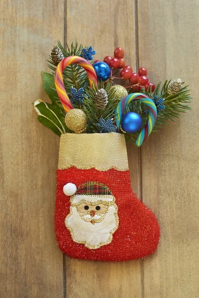 Christmas stocking with fir branches, berries and candy canes — Stock Photo, Image