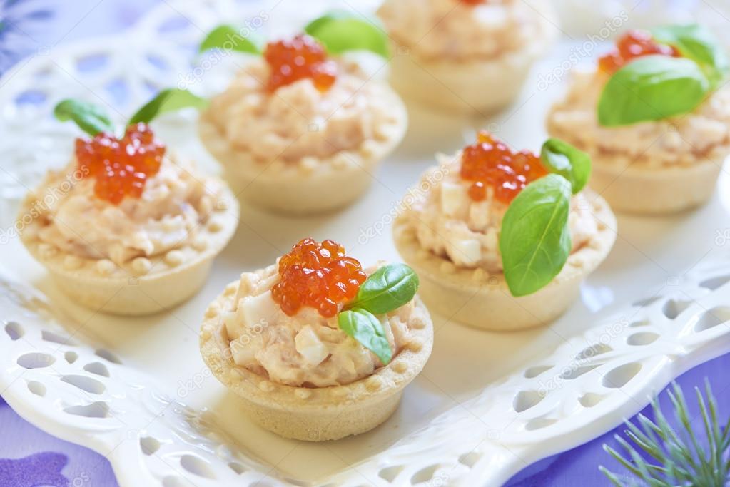 Tartlets with seafood salad, red caviar and basil