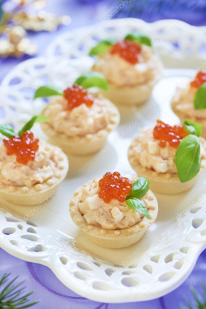 Tartlets with seafood salad, red caviar and basil