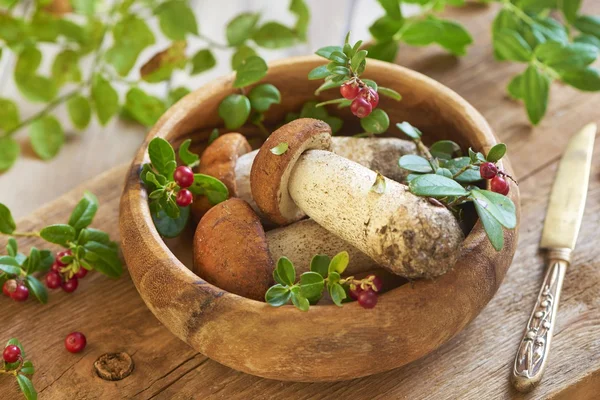 Fresh mushrooms with cranberry in wooden bowl — Stock Photo, Image