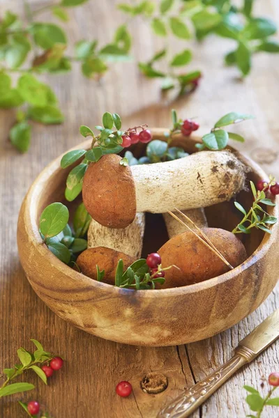 Fresh mushrooms with cranberry in wooden bowl — Stock Photo, Image