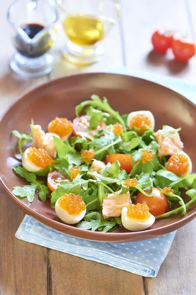 Salade de vacances avec saumon, oeufs de caille, tomates cerises et caviar rouge — Photo