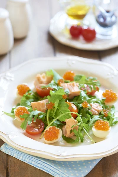 Салат с лососем, перепелиными яйцами, помидорами черри и красной икрой — стоковое фото