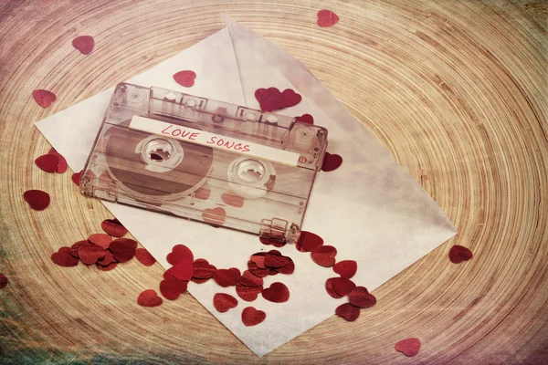 Audio cassette tape on red backgound with fabric heart — Stock Photo, Image