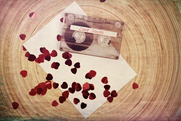 Audio cassette tape on red backgound with fabric heart — Stock Photo, Image