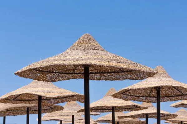 Beach umbrellas and blue sky background — Stock Photo, Image