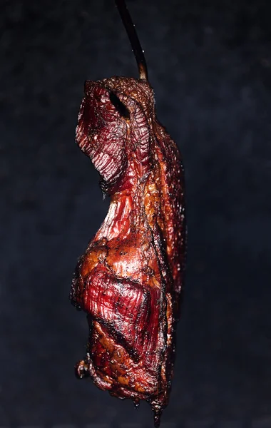 Курящая свиная шея в коптильне — стоковое фото