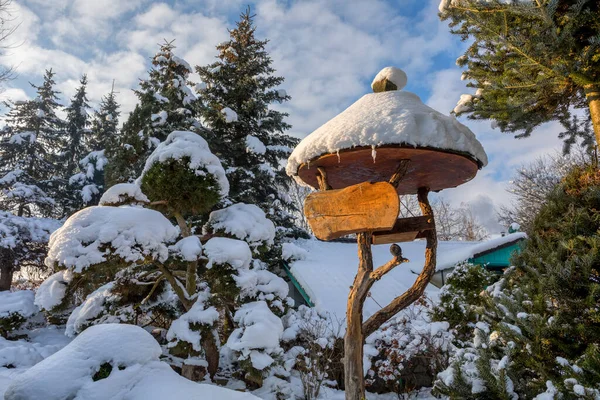 beautiful wooden signpost in winter garden covered with fresh snow