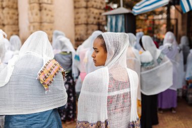 Azezo, Amhara Region, Ethiopia - April 21, 2019: Orthodox Christian people white dressed walk to mass on the street during easter holiday. Bahir Dar, Ethiopia