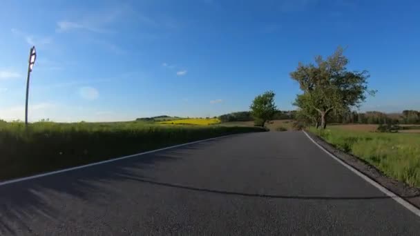 Auto rijden in het voorjaar platteland weg op een zonnige dag. — Stockvideo