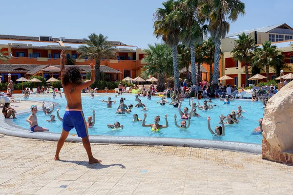 Turister på semester gör vattenaerobics i poolen — Stockfoto