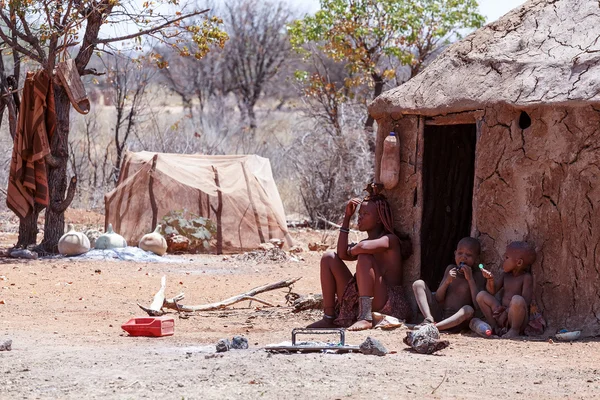 Himba vrouw met childs op de hals in het dorp — Stockfoto