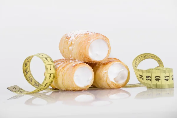 Concept of slimming, cakes with measuring tape — Stock Photo, Image