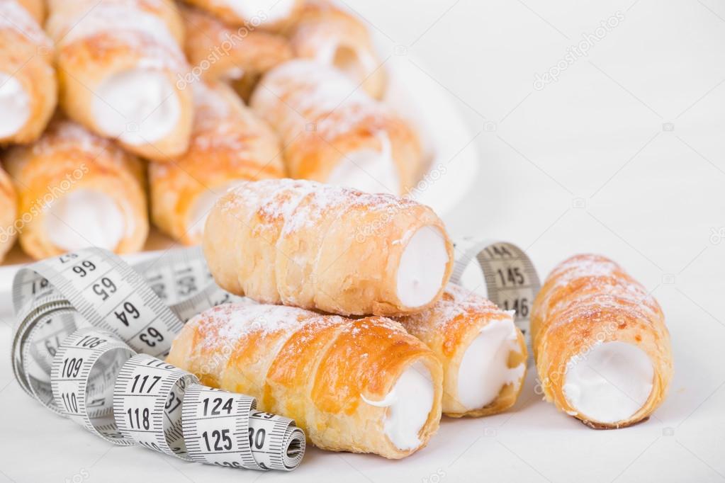 concept of slimming, cakes with measuring tape