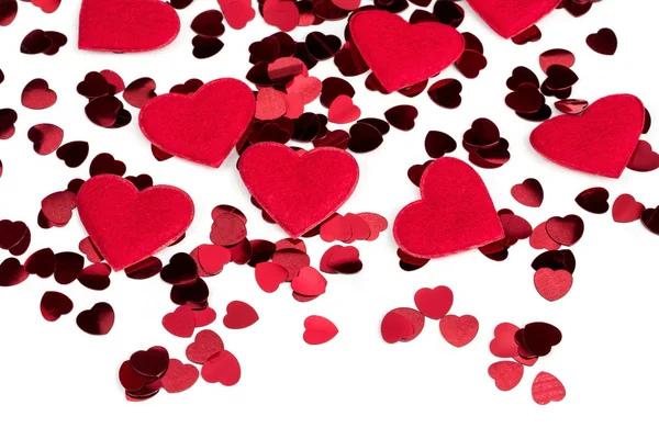 Red hearts confetti and fabric heart on white background — Stock Photo, Image