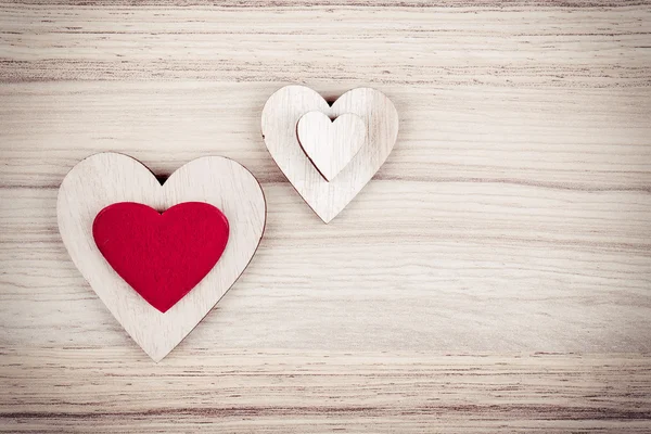 Valentijnsdag houten harten op een houten achtergrond — Stockfoto