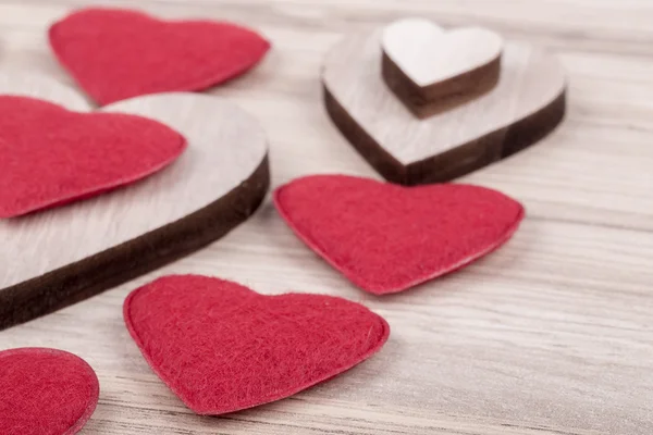 Tecido de Valentim e corações de madeira em um fundo de madeira — Fotografia de Stock