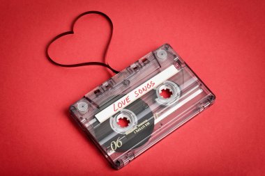 Audio cassette tape on red backgound. Film shaping heart clipart