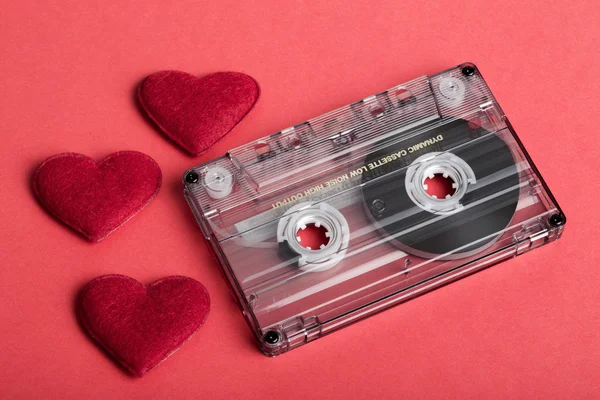 Cinta de casete de audio en fondo rojo con corazón de tela —  Fotos de Stock