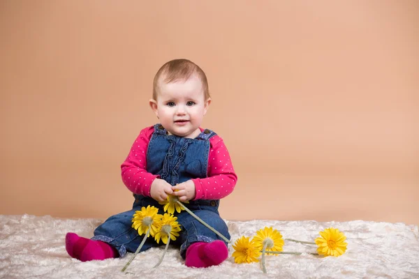 Bebé sonriente con flores amarillas —  Fotos de Stock