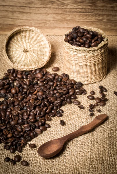 pile of fresh and bio aromatic coffee beans and spoon and jar