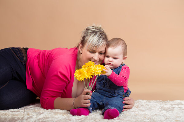 infant baby with his mom and yellow flowers