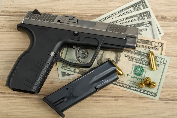 Pistool met kogel op ons dollar bankbiljetten — Stockfoto