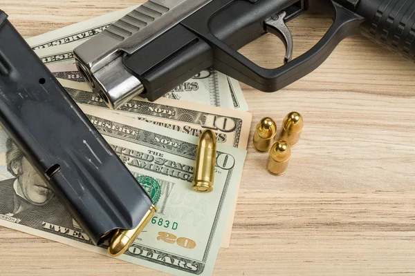 Pistool met kogel op ons dollar bankbiljetten — Stockfoto