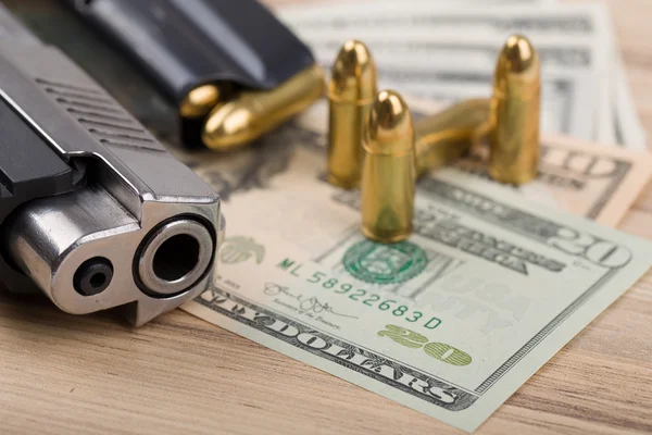 Pistool met kogel op ons dollar bankbiljetten — Stockfoto