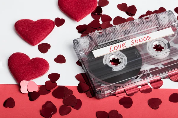 Zvuková kazeta na červené pozadí s tkaninou srdce — Stock fotografie