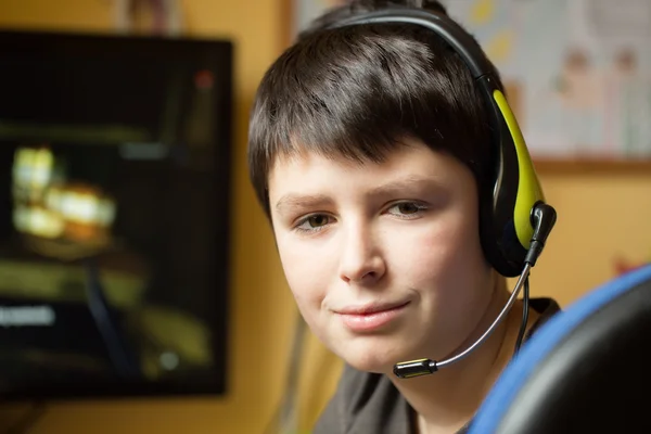 Хлопчик використовує комп'ютер вдома, граючи в гру — стокове фото