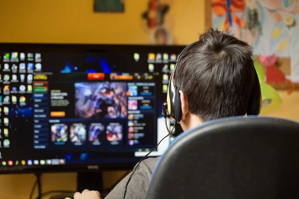 Niño usando la computadora en casa, jugando juego —  Fotos de Stock