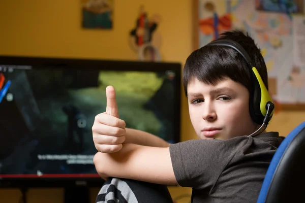 Niño usando la computadora en casa, jugando juego Fotos de stock