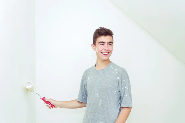 Подросток покрасил стену в белый цвет дома — стоковое фото