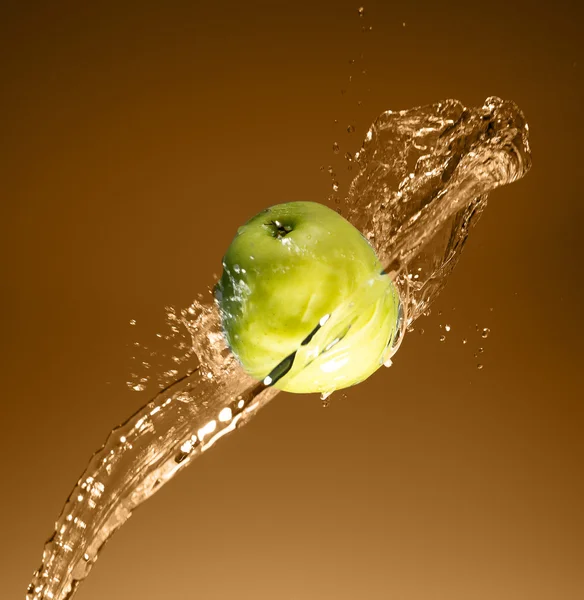 Manzana verde con salpicadura de agua, en beige —  Fotos de Stock