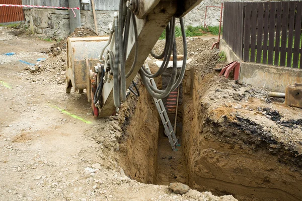 Vomere escavatore su trincea - costruzione di canalizzazione — Foto Stock