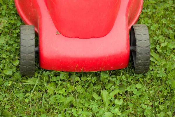 Červené sekačka na zelené trávě — Stock fotografie