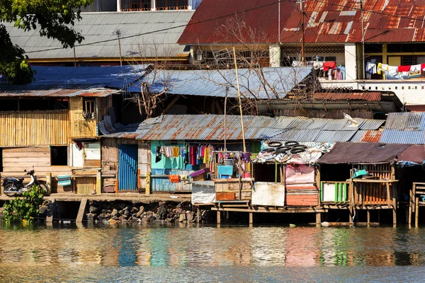 Paille maisons pauvres au bord de la rivière — Photo