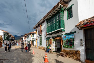 Villa de Leyva, Boyaca, Colombia - November 19 2023: Tourists and locals walk along the cobblestone streets lined with colonial buildings in Villa de Leyva.