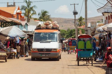 Miandrivazo, Madagascar - October 11 2025: An overloaded minivan (taxi-brousse) transporting goods and passengers through the bustling town of Miandrivazo.