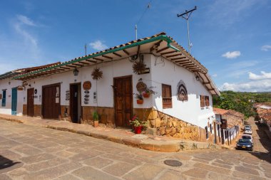 Barichara, Colombia - November 21 2023: View of traditional white and stone architecture with wooden doors on a preserved street in Barichara, Santander.