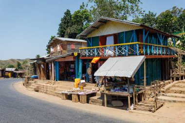 Ampasimbe, Toamasina Eyaleti, Madagaskar - 17 Ekim 2016: Ampasimbe köyündeki yol kenarı ahşap evler ve dükkanlar, bölgedeki basit mimari ve yerel ticaretin tipik bir örneği.
