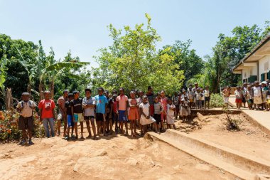 Brickaville, Toamasina Eyaleti, Madagaskar - 17 Ekim 2016: Her yaştan öğrenciler Toamasina Eyaleti 'ndeki basit sınıf binalarının önünde etkileşime giriyorlar.